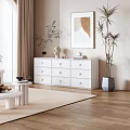 Modern White Shoe Cabinet With Multiple Drawers And Decorative Plants In Living Space