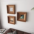 Portrait Paintings In Wooden Frames Hanging On Living Room White Wall With Leather Sofa