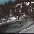 Stunning Snow Covered Alpine Mountain Scenery With Two Skiers Skiing On Wide Smooth Winter Slope