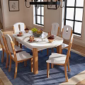 Round Dining Table Set with Six Wooden Chairs White Cushioned and Vase on Blue Rug