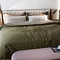 Double Bed With Green Checkered Quilt Wooden Headboard Purple Bench And Brown Chair