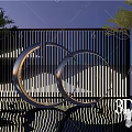 Modern Metal Circular Sculpture With Illuminated Design And Outdoor Screen Backdrop