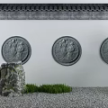 Traditional Building Exterior Wall with Circular Figure Relief Carvings and Garden Rocks Grass and Pine