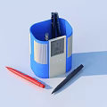 Pens in Blue Pen Holder with Red and Black Writing Tools on White Desk