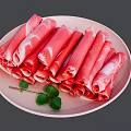 Fresh Sliced Lamb Meat Rolls on Pink Plate with Green Leaves Garnish