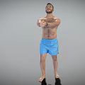 Shirtless Man in Blue Shorts Standing with Arms Stretched Forward Against Gray Background