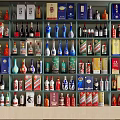 Assorted Wine Bottles and Glasses Arranged on Shelf with Various Brand Labels
