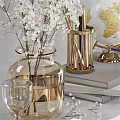 Decorative Accessories Set Featuring Gold Lamp Globe White Flowers Books And Stationery