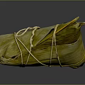 Traditional Chinese Zongzi Wrapped in Green Bamboo Leaves and Tied with String on Dark Glossy Surface