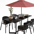 Black Outdoor Table with Red Umbrella Potted Small Tree Books and Bowls