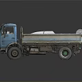 Blue Dump Truck Loaded With Tires And Other Items On Gray Background