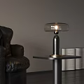 Modern Table Lamp with Transparent Lampshade and Metal Base Near Leather Sofa and Open Book