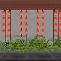 Traditional Red Lanterns Arranged on Wall with Lush Green Plants Below