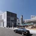 Modern Commercial Street With Perforated Wall Buildings Tower Outdoor Seating And Stone Paved Road