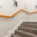 Modern Staircase With Wooden Handrail And Glass Railings Framed Pictures And Yellow Flowers