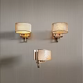 Three Modern Wall Lamps With Cream Textured Shades And Brushed Brass Bases On Gray Wall