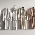 Various Colored Bathrobes and Towels Hanging on Wall Hooks with Soft Fabric