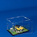Transparent Acrylic Box With Yellow SUV Model Grass Sign Plants Figures On Blue Background