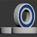 Household Bearings With Silver Blue And Red Rings Stacked On Surface