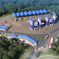 Industrial Factory Aerial View With Green Forest Surroundings Blue Roof Structures Roadways And Vehicles