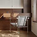 Modern Single Chair With Metal Frame Gray Cushion In Wooden Room With Sunlight Through Blinds
