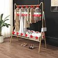 Golden Metal Clothes Rack With Hanging Clothes Woven Basket And Shoes In Home Setting