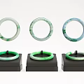 Three Elegant Green And White Jade Bracelets On Black Display Stands