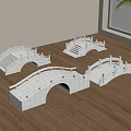 Four White Stone Arch Bridge Models Placed on Wooden Floor Near Window and Plant