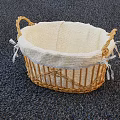 Wicker Storage Basket With Light Fabric Lining And White Lace Trim On Dark Carpet