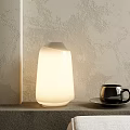 Modern White Illuminated Table Lamp with Black Mug and Textured Gray Wall Background