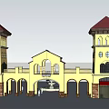 Mediterranean Style Entrance Gate With Yellow Exterior Towers Red Roofs And Arched Doorways