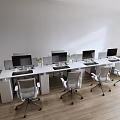 White Office Desk with Multiple Monitors Green Plants and Silver Chairs on Wooden Floor