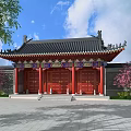 Traditional Ancient Architecture With Overhanging Black Tiled Eaves Red Wooden Doors And Pink Flowering Trees