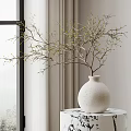 White Textured Ceramic Vase Holding Green Bud Twigs On Marble Table Near Window Curtain
