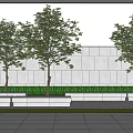 Deciduous Trees in Front of Gray Wall with Stone Benches Grass Lawn and Gravel