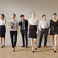 Group of Business Professionals in Formal Attire Walking With Documents and Coffee Cups