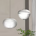 Round Striped Paper Pendant Lights Hanging in Room with Light Wall and Green Plant
