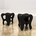 Unique Black Stools with Hollow Seat and Curved Legs on Marble Floor