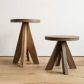 Two Wooden Stools With Round Seats Three Legs Light And Dark Wood Tones On Wooden Floor