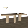 Light Wood Dining Table with Three Cylindrical Legs in Bright Room with Pendant Light
