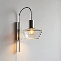 Modern Wall Sconce With Curved Metal Arm And Transparent Glass Shade On White Wall