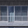 White Metal Grid Design Balcony Railings On Multi story Building With Gray Wall