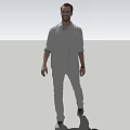 Man In Casual Gray Shirt And Pants Standing Against Simple Background