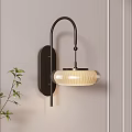 Modern Sleek Wall Lamp With Metal Bracket And Textured Shade On Beige Wall Beside Green Plant