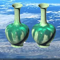 Two Green Ceramic Vases With Tall Neck And Rounded Glossy Body On Beige Background