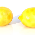 Fresh Ripe Yellow Lemons with a Knife Placed Between the Two