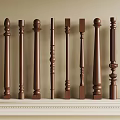 Various Brown Wooden Decorative Columns Arranged On White Shelf With Intricate Designs