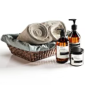 Wicker Basket With Soft Rolled Towels And Liquid Soap Bottles