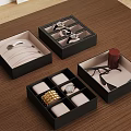 Black Jewelry Boxes With Compartments Holding Watches Necklaces Bracelets And Eyeglasses On Wooden Tabletop