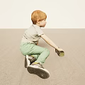 Young Boy With Red Hair Sitting On Light Floor Holding Toy Car In Gray T Shirt Green Pants